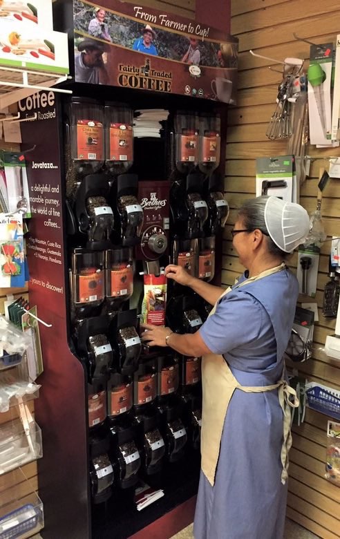 Esther re-stocks coffee on shelves at the Kauffman Family Marketplace.
